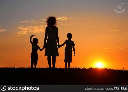 Mother and children on sunset silhouette