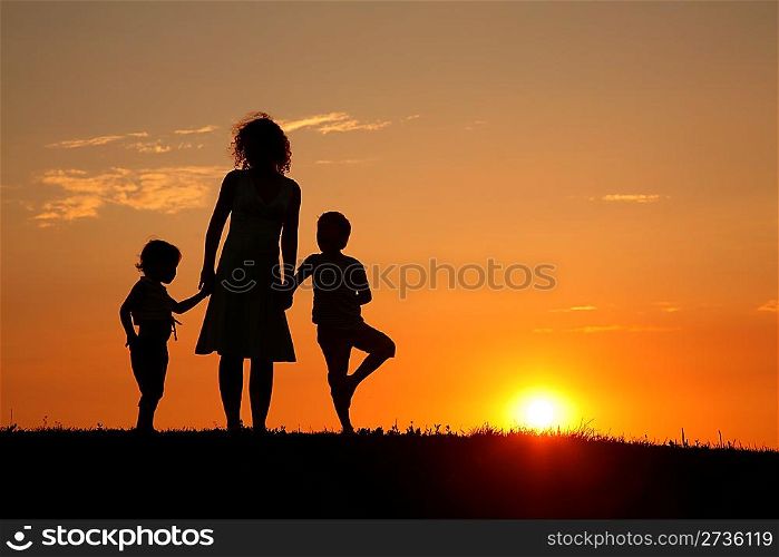 Mother and children on sunset silhouette