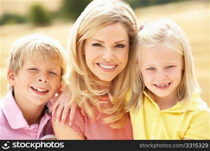 Mother And Children Sitting On Straw Bales In Harvested Field