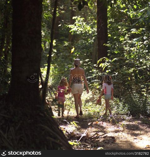Mother and children walking through forest