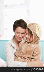 Mother and daughter (5-6) embracing and smiling girl in bunny costume