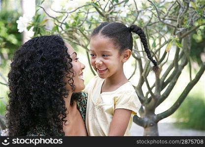 Mother and daughter (5-6 years) in garden