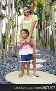 Mother and daughter (5-6 years) standing on path