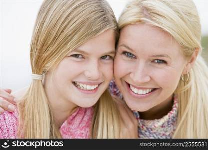 Mother and daughter at beach smiling