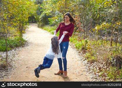 Mother and daughter being spun in circles at park having fun