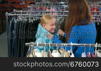 Mother and daughter choosing clothes in a clothing store, trying on jacket