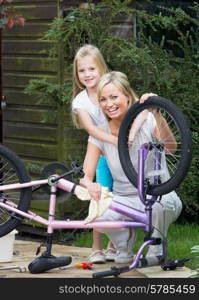 Mother And Daughter Cleaning Bike Together