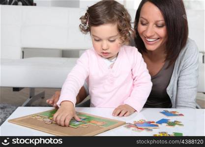 Mother and daughter completing jigsaw