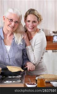 Mother and daughter cooking crepes together