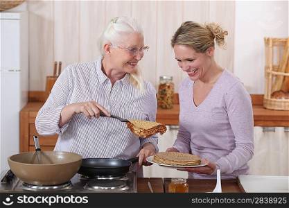 Mother and daughter cooking pancakes
