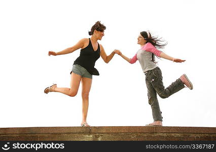 mother and daughter dance on the rock wall