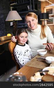 Mother and daughter eating breakfast together