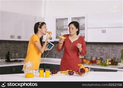 Mother and daughter eating fruit