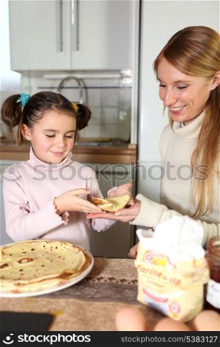 Mother and daughter eating pancakes