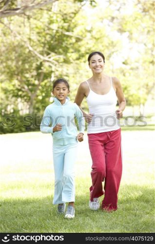 Mother And Daughter Exercising In Park