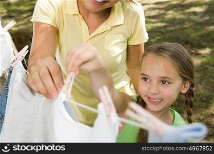Mother and daughter hanging out washing