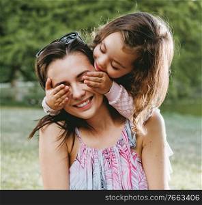 Mother and daughter having a great fun in the summer park