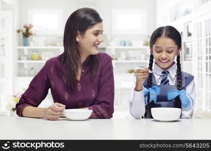 Mother and daughter having breakfast together