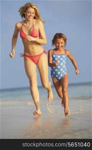 Mother And Daughter Having Fun In Sea On Beach Holiday