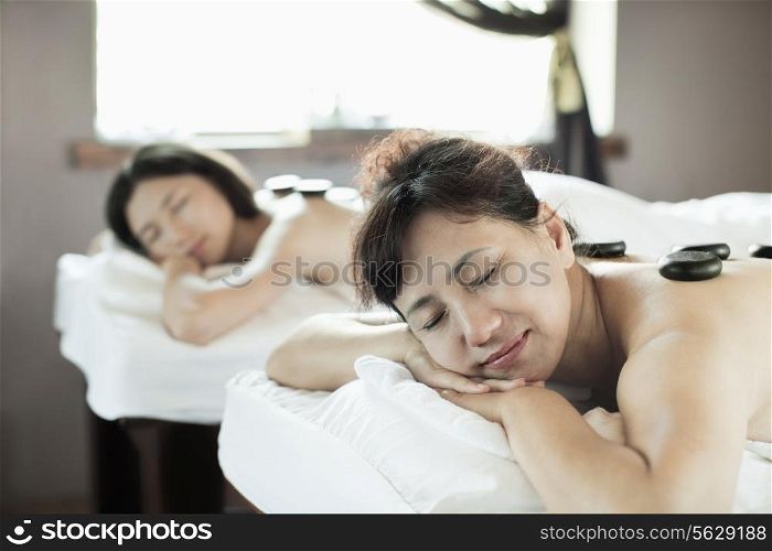 Mother and Daughter Having Hot Stone Massage Together