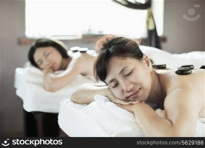 Mother and Daughter Having Hot Stone Massage Together