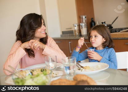 Mother and daughter having lunch in the kitchen