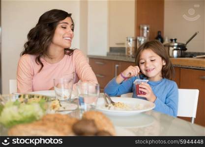 Mother and daughter having lunch in the kitchen
