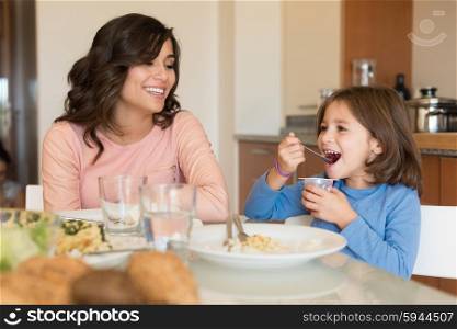 Mother and daughter having lunch in the kitchen