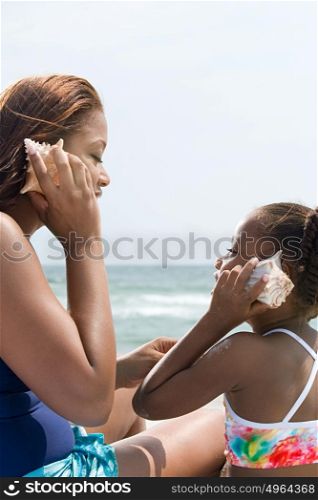 Mother and daughter holding shells