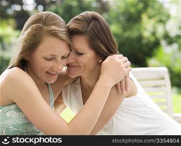 mother and daughter hug in garden