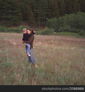 Mother and daughter hugging in field