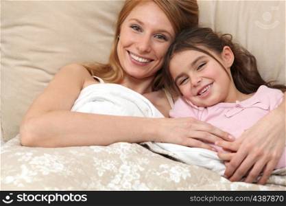 Mother and daughter in bed together