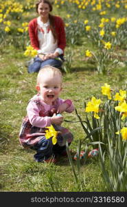 Mother And Daughter In Daffodil Field With Decorated Easter Eggs