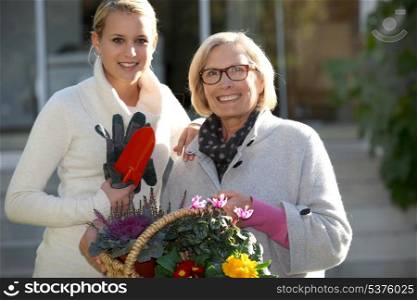 Mother and daughter in garden with flower basket