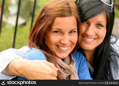 Mother and daughter in the park smiling teen together loving