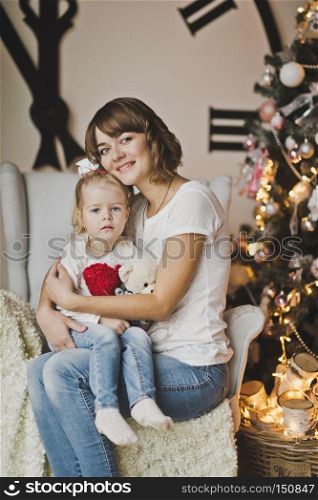 Mother and daughter in the white chair in front of a huge clock.. Family portrait in front of a huge white pointer hours 7261.