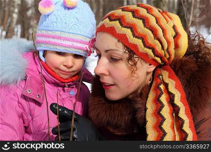 Mother and daughter in wood in winter closeup, mother shows gemma
