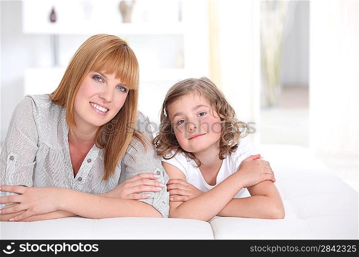 Mother and daughter laying on couch