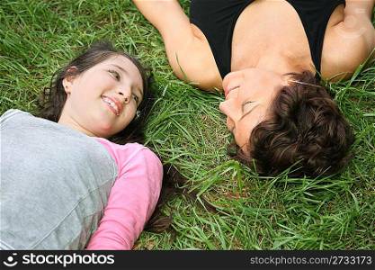 mother and daughter lie on the grass 2