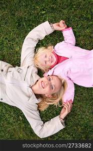 mother and daughter lie on the grass and look upward 3