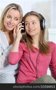 Mother and daughter listening to music whit headphones