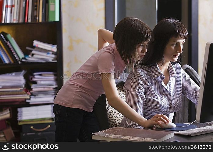 Mother and daughter looking at computer screen