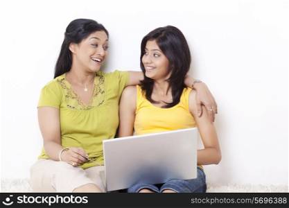 Mother and daughter looking at each other while shopping online