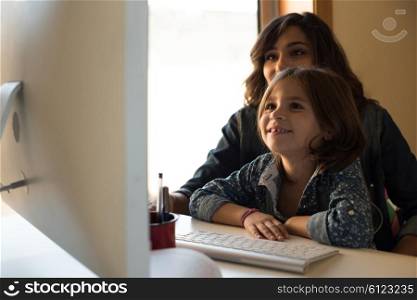 Mother and daughter looking to the computer