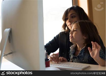 Mother and daughter looking to the computer