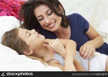 Mother And Daughter Lying In Bed Together
