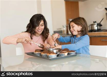 Mother and daughter making cupcakes in kitchen