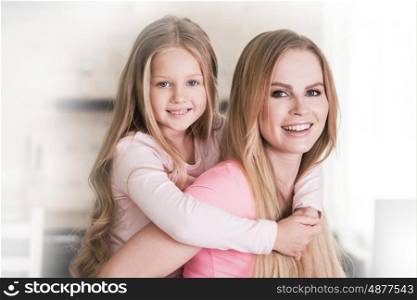 Mother and daughter. Mother and piggy back ride daughter at home