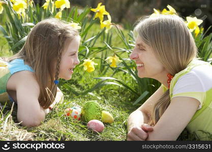 Mother And Daughter On Easter Egg Hunt In Daffodil Field