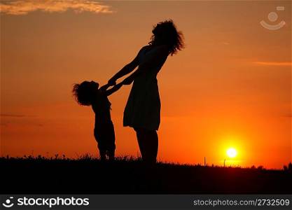 Mother and daughter on sunset watching on sky
